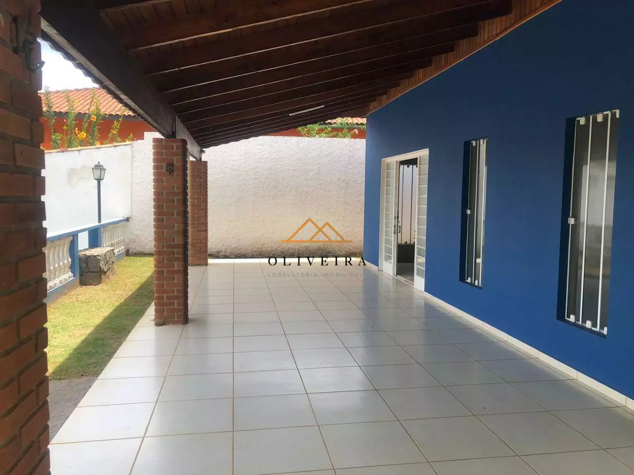 Varanda lateral coberta com vista para o jardim