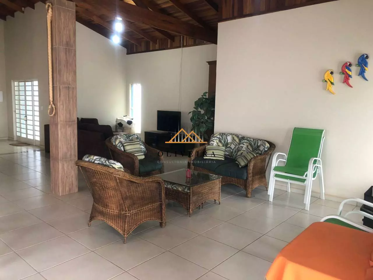 Sala de estar com poltronas de vime e TV